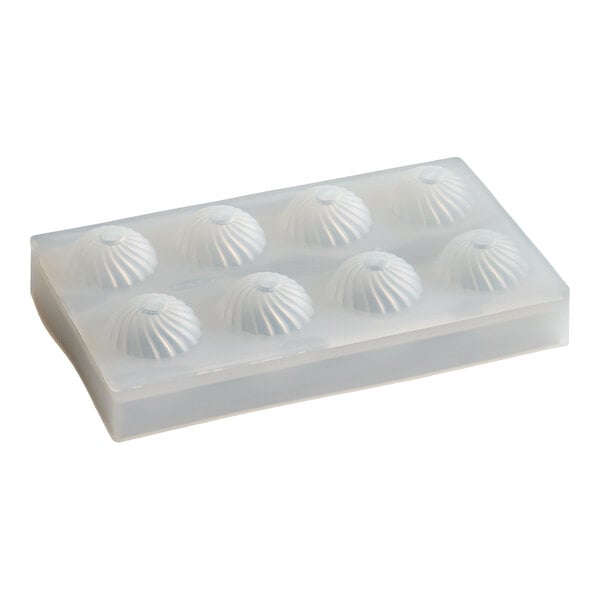 A clear silicone chocolate mold with eight dome-shaped compartments for making spherical chocolates.