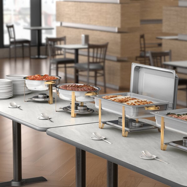 A full size stainless steel chafer with gold accents used for serving hot food at buffets or events.