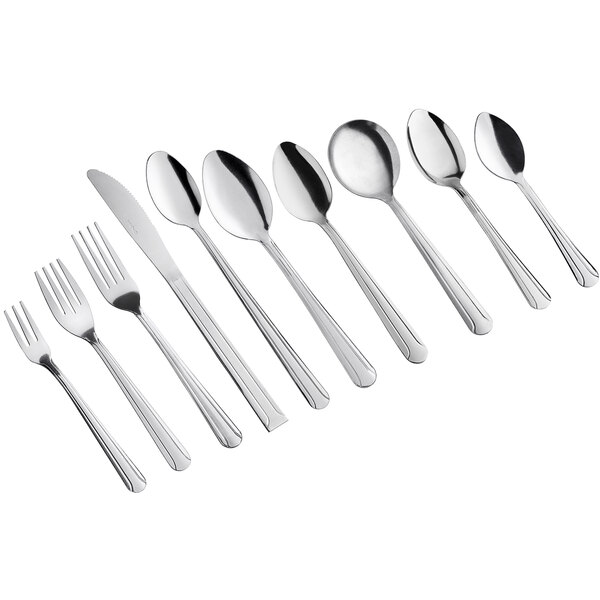 A set of stainless steel salad forks and other cutlery pieces arranged in a row.