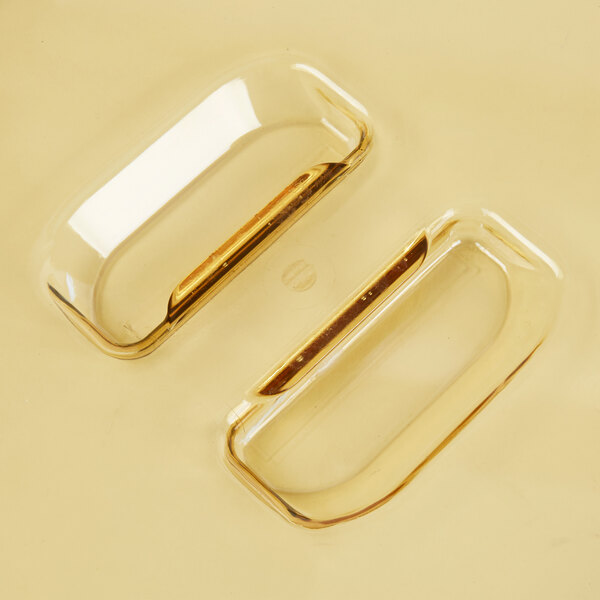 A Vollrath amber plastic lid with slotted openings over a glass dish.