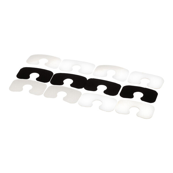 A set of black and white rectangular shims with U-shaped cutouts, arranged in rows.