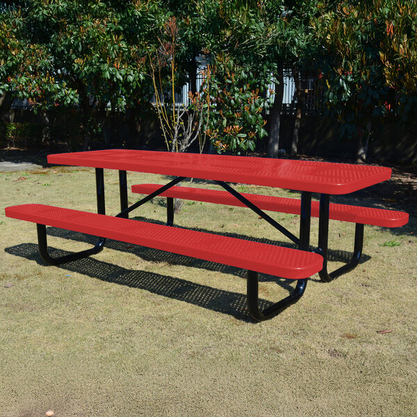 An 8-foot red perforated metal picnic table with attached benches and black metal legs, situated outdoors on grass.