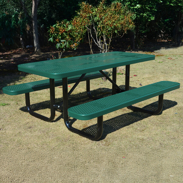 A green perforated metal picnic table with attached benches and black metal legs.