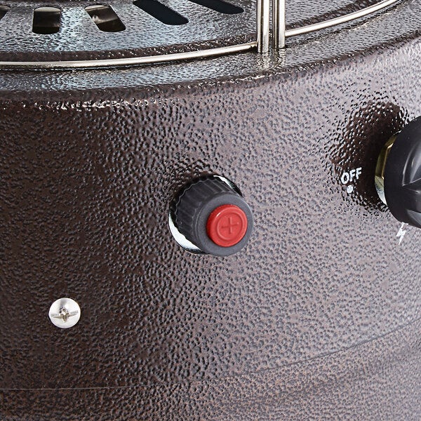 A close-up of a replacement ignitor installed on a textured metal patio heater.