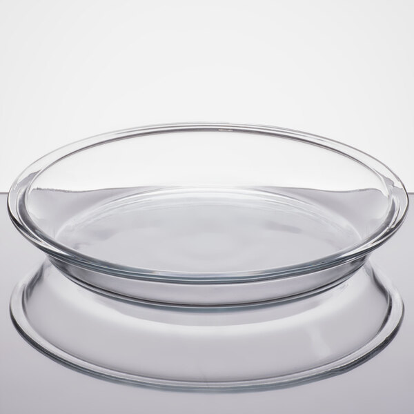 A clear glass pie pan with a round shape and slightly flared rim.