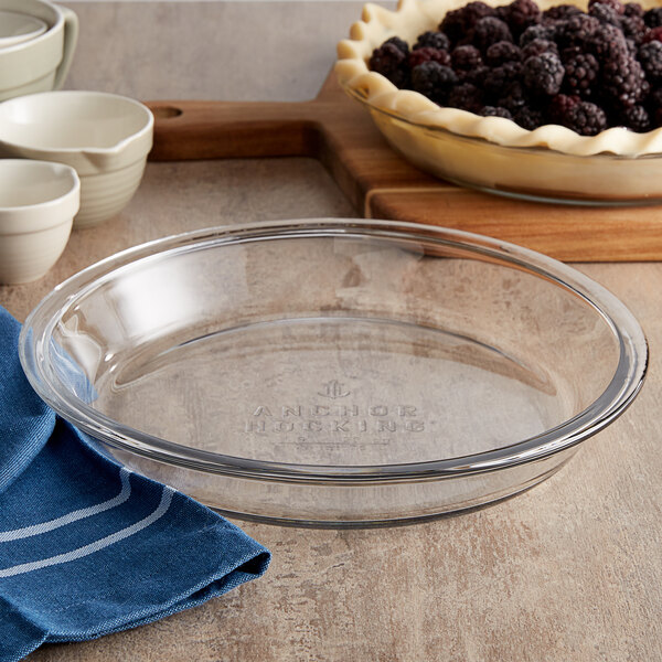 A clear glass pie pan with a slightly raised rim, suitable for baking pies.