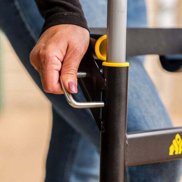 A close-up of a person operating the handle latch on a Gorilla steel convertible hand truck or cart.