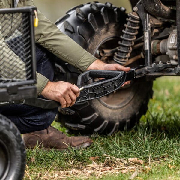 A person attaching a Gorilla 1,200 lb. Steel Utility Cart to an off-road vehicle.