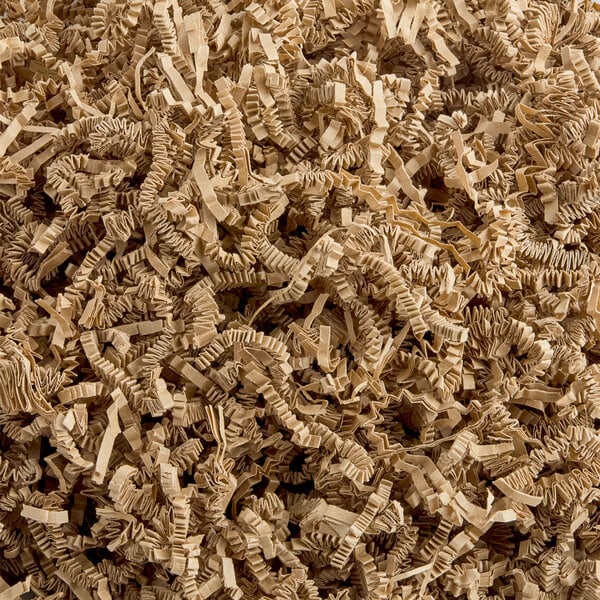 A pile of brown crinkle-cut kraft paper shred used for packaging or gift baskets.