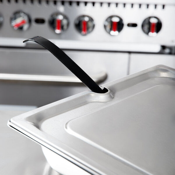 A Vollrath stainless steel slotted cover on a stainless steel tray.