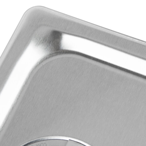 A Vollrath stainless steel slotted lid on a metal counter.