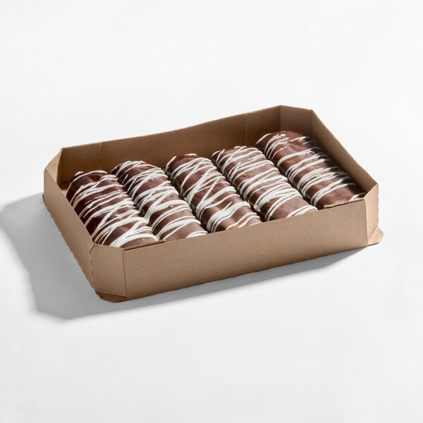 A box of chocolate iced, buttercreme-filled Long John donuts with white icing drizzle.