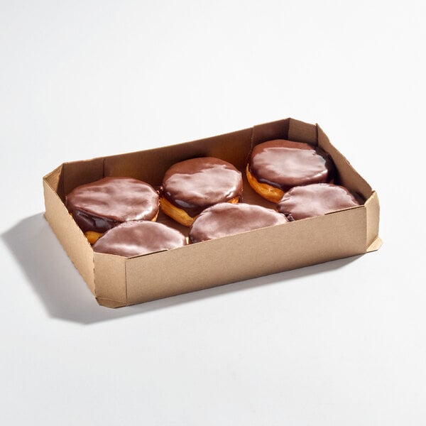 A cardboard box containing six Boston creme donuts with chocolate icing on top.