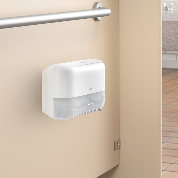 A white double roll toilet tissue dispenser mounted on a restroom partition.