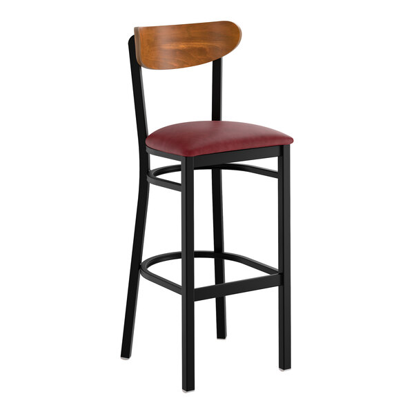 A black bar stool with a burgundy vinyl seat and a curved wooden backrest.