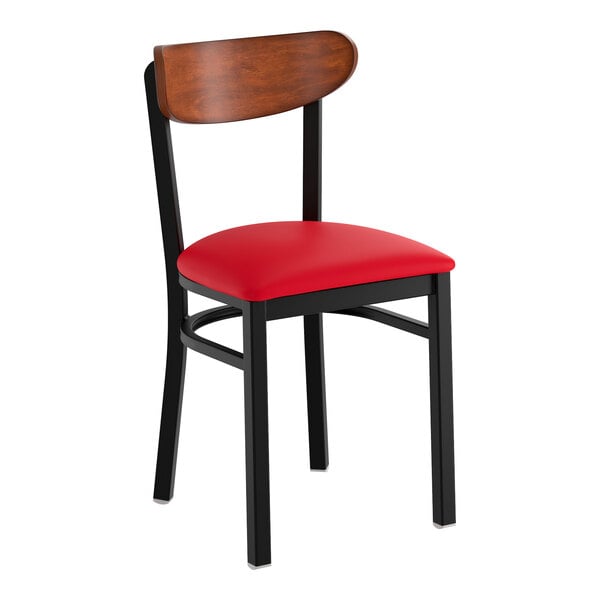 A black metal chair with a red vinyl seat and an antique walnut wood backrest.