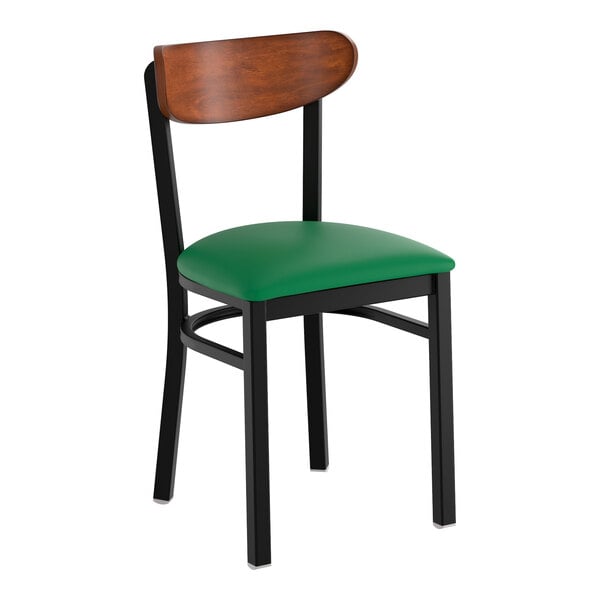 A black metal chair with a green vinyl seat and an antique walnut wood backrest.