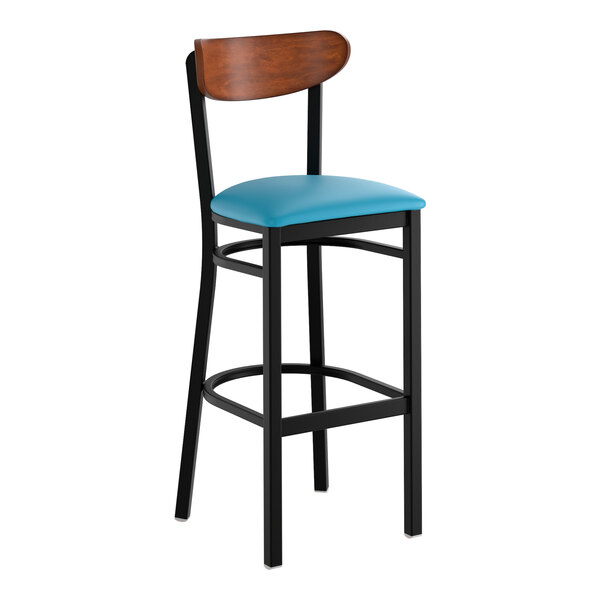 A black metal bar stool with a blue vinyl seat and an antique walnut wood backrest.