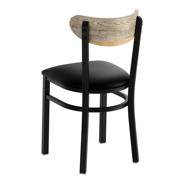 A black metal chair with a black vinyl seat and a curved driftwood-finish wooden backrest.