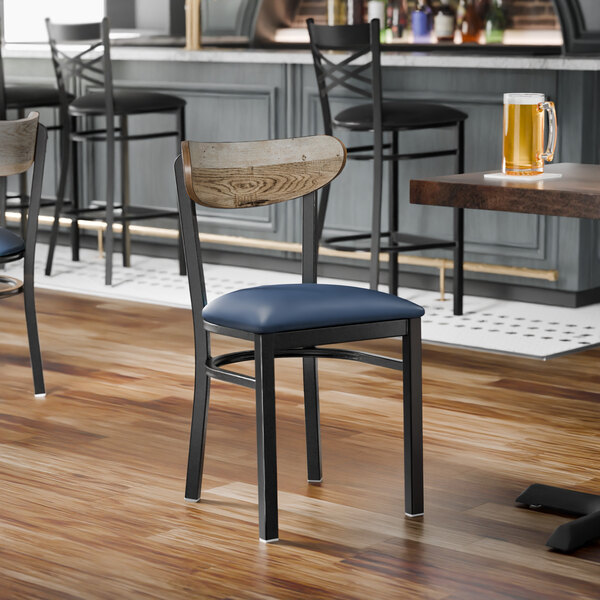 A black metal chair with a navy vinyl seat and a driftwood-finished wooden backrest.