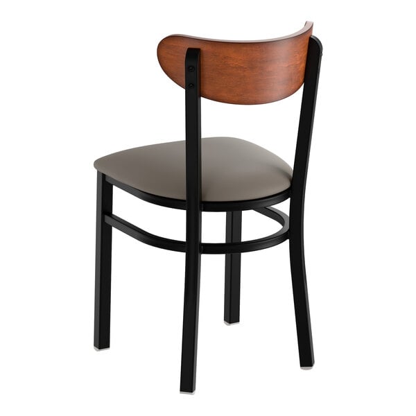A black metal chair with a dark gray vinyl seat and an antique walnut wood backrest.