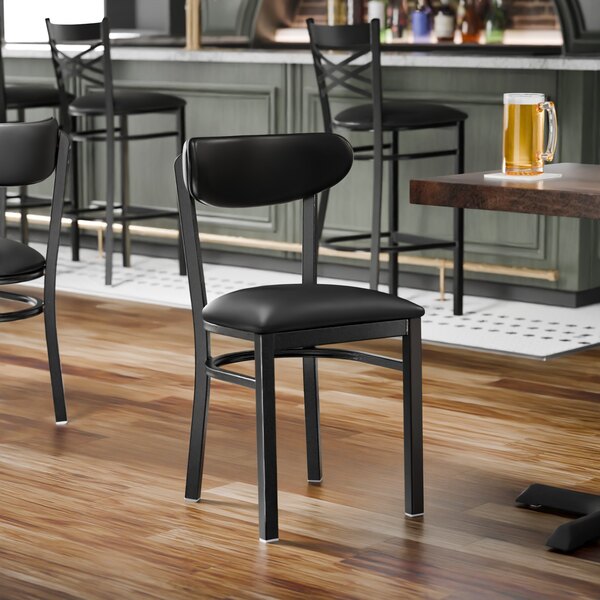 A black metal chair with a black vinyl seat and backrest.