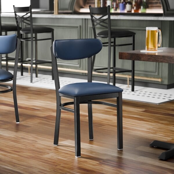 A black metal chair with a navy vinyl seat and backrest, shown unassembled.