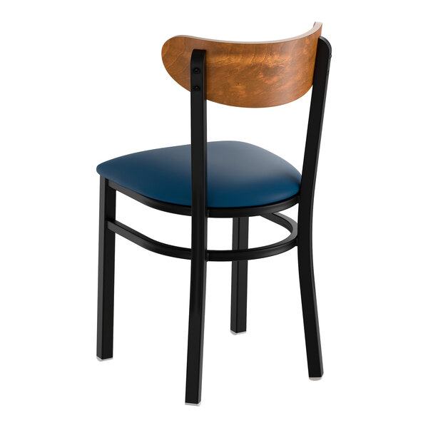 A black metal chair with a navy vinyl seat and a curved vintage wood backrest.