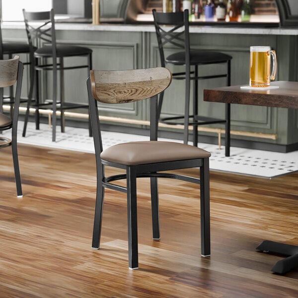 A black metal chair with a taupe vinyl seat and a driftwood-finished wooden backrest.