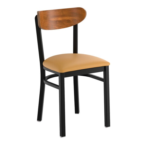 A black metal chair with a light brown vinyl seat and a curved vintage wood backrest.
