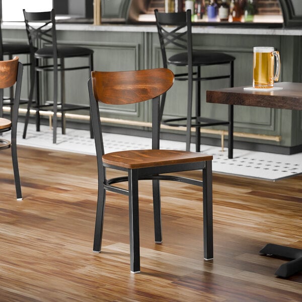 A black metal chair with a vintage wood seat and back, shown unassembled.