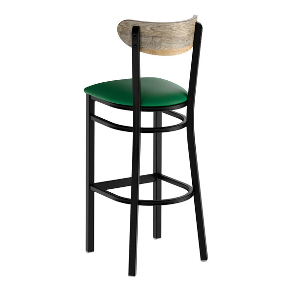 A bar stool with a black metal frame, green vinyl seat, and a driftwood-finished wooden backrest.