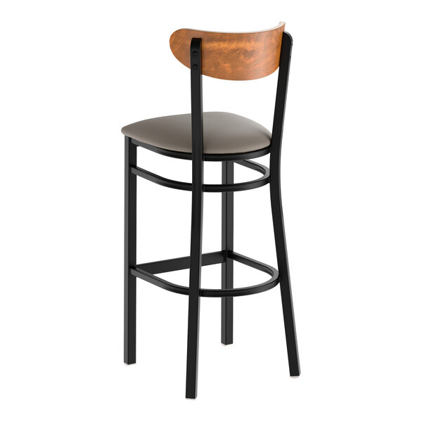 A black metal bar stool with a dark gray vinyl seat and a curved vintage wood backrest.