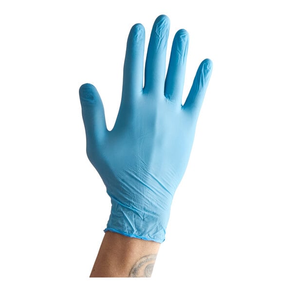 A blue nitrile powder-free exam glove worn on a hand.