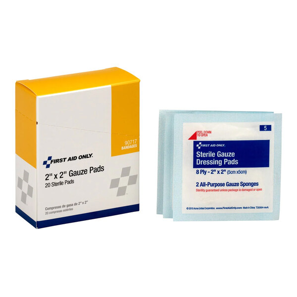 A box of First Aid Only 2x2 inch sterile gauze pads with individual sterile dressing pad packets.