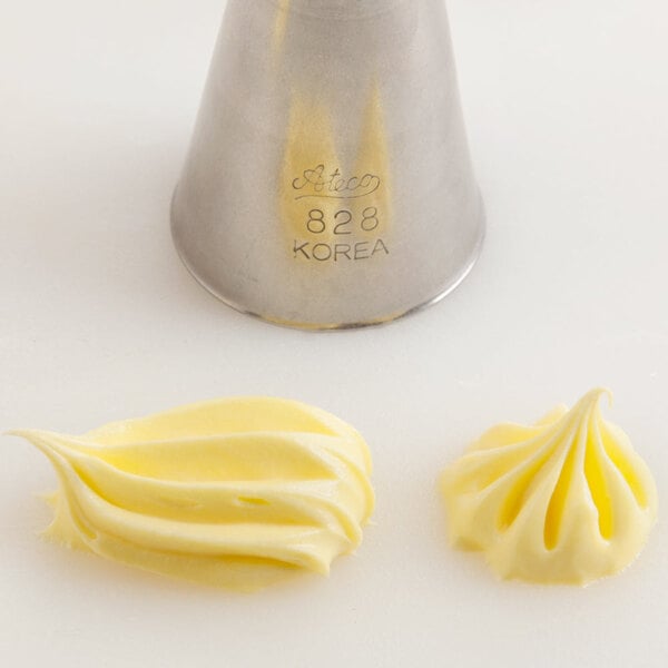 A stainless steel open star piping tip labeled 'Ateco 828 Korea' with two examples of piped frosting beside it.