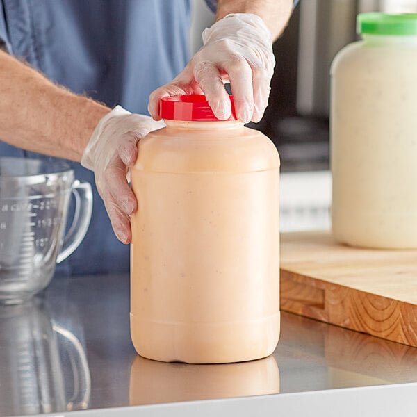 A large one-gallon plastic container with a red cap, used for food storage.