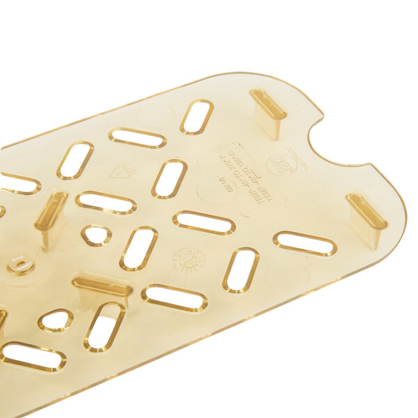 A gold plastic Vollrath Super Pan drain tray with holes.