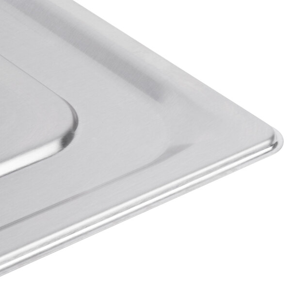 A Vollrath stainless steel slotted lid on a metal tray.