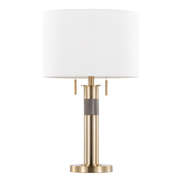 A gold table lamp with a cylindrical base and a white linen drum shade.