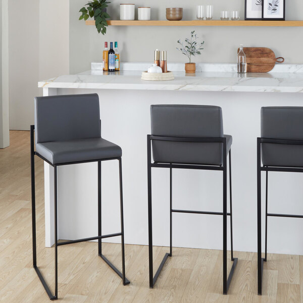 A modern barstool with a black steel frame and gray faux leather back and seat.
