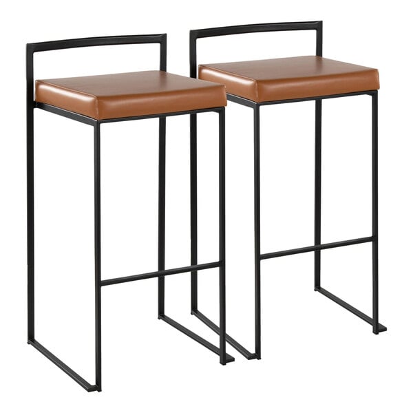 A pair of black metal barstools with low backs and camel-colored faux leather seats.