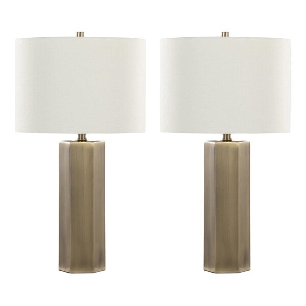 A pair of antique brass table lamps with white linen drum shades.