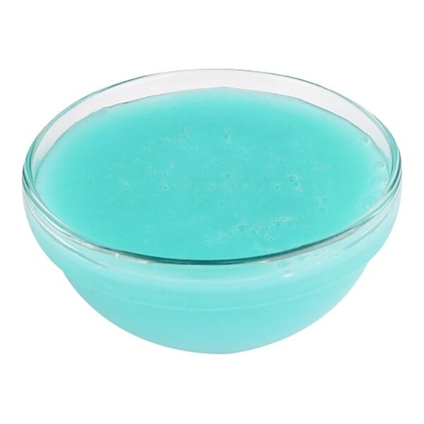 A glass bowl filled with light blue frozen yogurt mix.