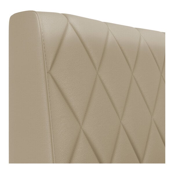A close-up view of a beige diamond-tufted upholstered booth backrest.