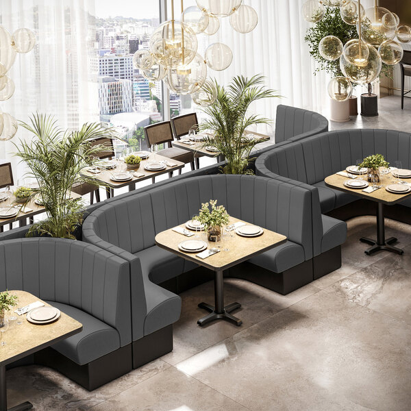 A graphite-colored, quarter-circle corner booth with channel tufting and a 36-inch high back, designed for restaurant seating.