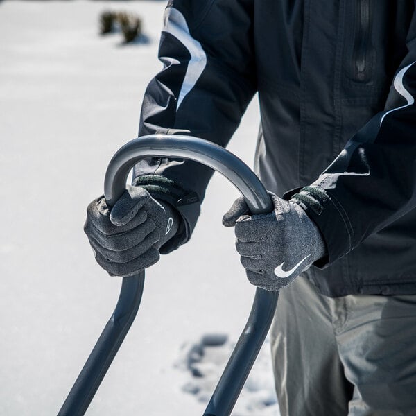 A person using a True Temper SnoBoss 26-inch poly blade snow shovel with a multi-grip handle in a snowy outdoor setting.