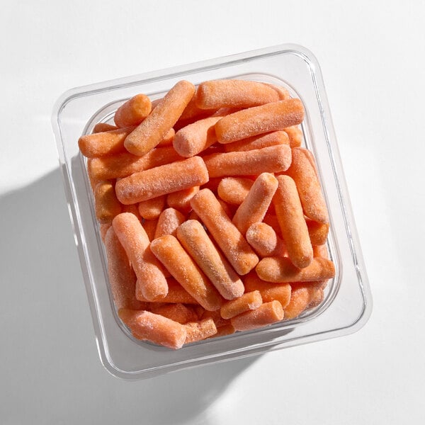 A clear plastic container filled with individually quick frozen whole baby carrots.