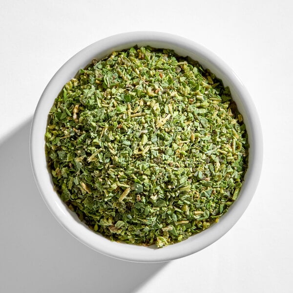 A white bowl filled with chopped dried oregano.