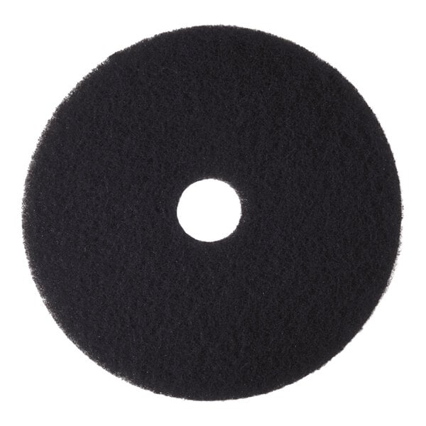 A round, black high-performance stripping floor pad with a central hole.